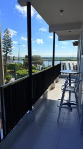 a balcony with a table and chairs looking out at the water at Pousada carioca in São João da Barra