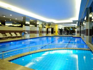 a large swimming pool with blue water in a building at Mercure Istanbul Bakirkoy in Istanbul