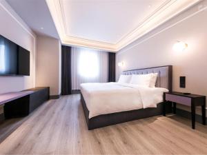 a bedroom with a bed and a desk and a television at Mercure Xi'an Qujiang in Xi'an +162 photos