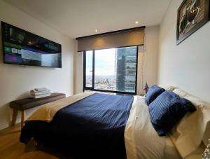 a bedroom with a large bed and a large window at AH/Luxe penthouse con balcón,Wifi+Parking; Usaquén in Bogotá