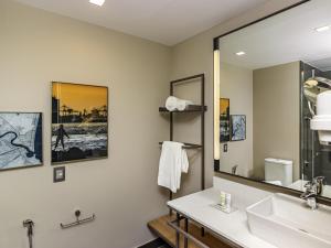 a bathroom with a sink and a mirror at Mercure Itajai Navegantes in Itajaí