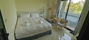 a bedroom with a bed and a large window at 金門民宿 x 花藝雅築 The Flower Hut in Jinhu