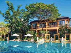 a resort with a swimming pool in front of a building at Mövenpick Asara Resort & Spa Hua Hin in Hua Hin