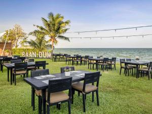 a group of tables and chairs on the beach at Mövenpick Asara Resort & Spa Hua Hin in Hua Hin