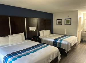 a hotel room with two beds with blue and white sheets at GuestHouse Inn Dothan in Dothan