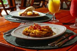 a table with two plates of breakfast food and drinks at Pao Pao Cartagena in Isla Grande