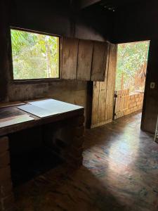 une pièce vide avec deux fenêtres et une table dans l'établissement Casa Aconchego, 7 km de São Jorge, à Alto Paraíso de Goiás