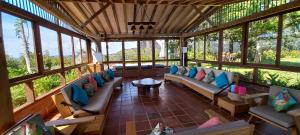 a screened in porch with couches and a table at Casa de Campo Bheta in Guatapé