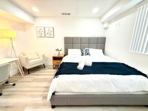 ein Schlafzimmer mit einem großen Bett und einem Stuhl in der Unterkunft GilmoreOne in Van Nuys