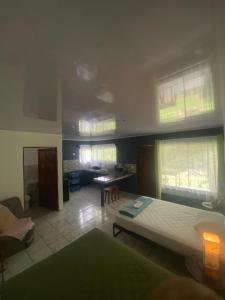 a bedroom with a bed and a table and windows at Villa Granja Agua Azul-wi-fi-AC-6 Personas-parqueo in Agua Azul