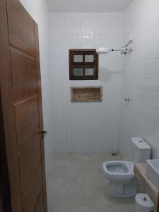 a bathroom with a toilet and a window at Casa da matta in Ubatuba