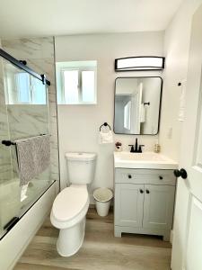 a bathroom with a toilet and a sink and a mirror at GilmoreOne in Van Nuys