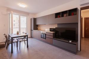 a living room with a table and a kitchen at Residence Black Line - Affitti Brevi Italia in Foggia