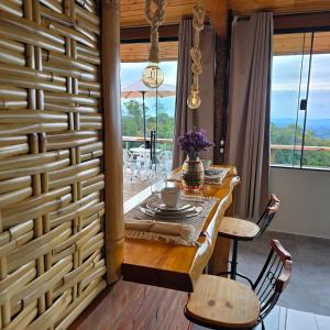 a dining room with a table and chairs and a wooden wall at Chalé Pôr do Sol in Cunha