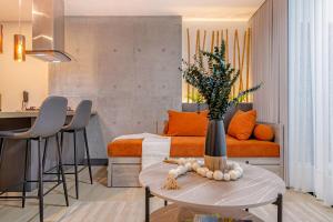 a living room with a couch and a table with a vase at R211 Loft with large balcony, infinity pool and spa in Estación El Salto