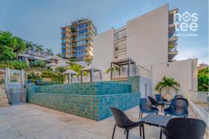a group of chairs and tables in front of a building at R211 Loft with large balcony, infinity pool and spa in Estación El Salto