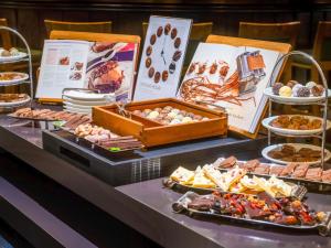 a buffet with different types of food on a table at Mövenpick Hotel Nürnberg Airport in Nürnberg