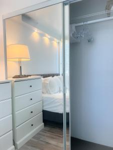 une chambre avec un lit et un miroir dans l'établissement Picturesque Pacific Monarch condo, à Honolulu