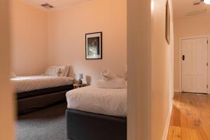 Dos camas en una habitación con paredes naranjas. en Bicheno Beach House, en Bicheno 26 fotos más