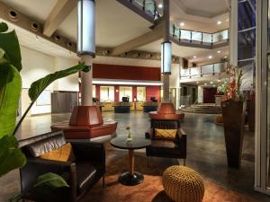 a lobby with leather chairs and a table at Mövenpick Hotel Münster am Aasee in Münster