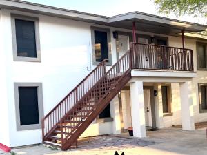 a house with a wooden staircase in front of it at NEW! 2 minutes from Convention Center, Palms Crossing Shopping & South Texas College in McAllen