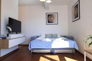 Un dormitorio con una cama azul y un televisor. en Valmere Members Luxury Sea View Apartment Tivat, en Tivat