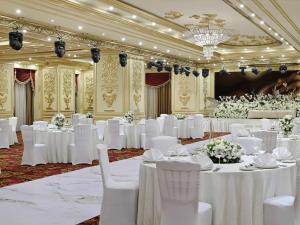 a banquet hall with white tables and white chairs at Mövenpick Hotel City Star Jeddah in Jeddah