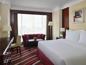 a hotel room with a bed and a chair and a window at Mövenpick Hotel City Star Jeddah in Jeddah +113 photos