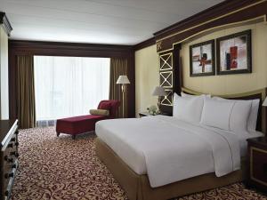 a hotel room with a large bed and a chair at Mövenpick Hotel City Star Jeddah in Jeddah +114 photos