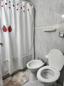 Un baño con inodoro y cortina de ducha. en Namaste, en Río Gallegos