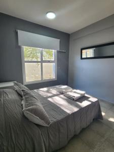 Un dormitorio con una cama grande con ventana. en Namaste, en Río Gallegos