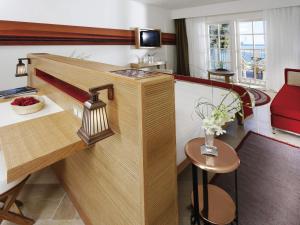 Habitación de hotel con escritorio y sofá rojo en Movenpick Resort & Spa El Gouna, en Hurghada