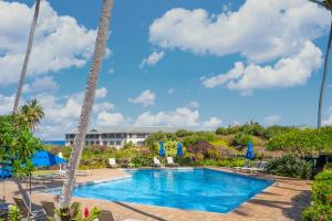 una piscina con palmeras y un complejo en Poipu Sands by OUTRIGGER, en Koloa