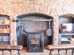 a stone fireplace in a living room with two chairs at Hayfield - Uk35890 in Turriff