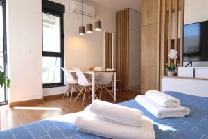 Un dormitorio con una cama azul con toallas blancas. en Valmere Members Luxury Sea View Apartment Tivat, en Tivat