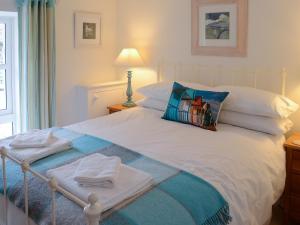 a white bed with towels and a pillow on it at The Byre in Rispond