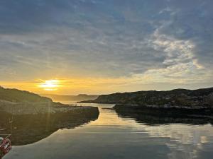 a river with the sun setting in the distance at The Byre in Rispond +4 photos