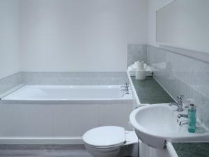 a bathroom with a tub and a toilet and a sink at The Cottage in Rispond