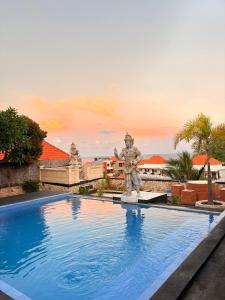 a statue sitting next to a swimming pool at Pooja Ocean View Cottage in Nusa Penida