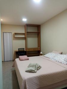 a bedroom with a bed with two towels on it at Casa Urban 56 - Pet Friendly - Vaga - Cama King in Belém