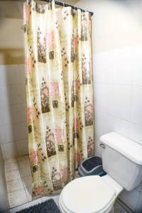 Un baño con inodoro y cortina de ducha. en Rancho Mayayi Beach house, en San Miguel 41 fotos más