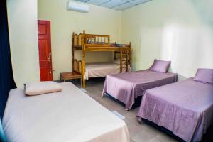 una habitación con dos camas y una litera en Rancho Mayayi Beach house, en San Miguel