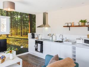 een keuken met witte kasten en uitzicht op het bos bij Oak - Uk50462 in Alvington