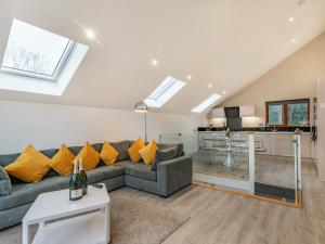 sala de estar con sofá gris y almohadas amarillas en Waterside Lodge Four - Uk36706, en Southowram