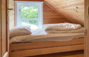 two beds in a room with a window at Gorgeous Home In Leinøy With House Sea View in Fosnavåg