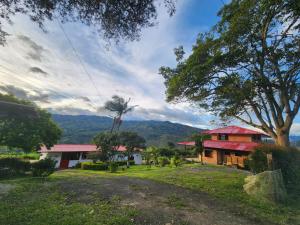 a house with a red roof in the middle of a field at Finca Campestre El Descanso in Somondoco