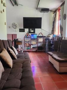 a living room with couches and a flat screen tv at Finca Campestre El Descanso in Somondoco
