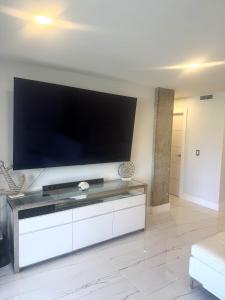 a living room with a large flat screen tv at Contemporary Waterfront Condo in North Palm Beach