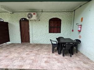 ein Raum mit einem Tisch und Stühlen und einem Fenster in der Unterkunft Pousada Charle Brown in Garopaba