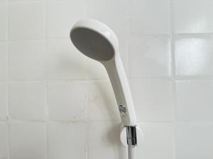 a white toothbrush hanging on a tiled wall at 玄関開けたらスキー場!400平米の贅沢空間で大型犬もOKシアタールーム完備 Skiin 400m2 Luxury Lodge Large Dogs OK Big Theater Room in Yonezawa +45 photos